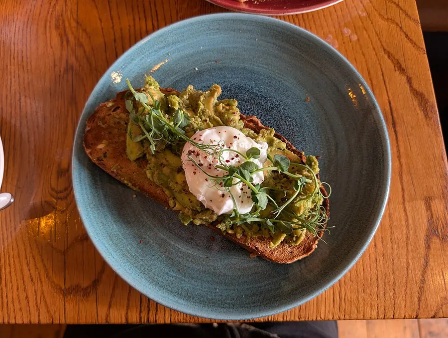 Avocado toast with a poached egg on a blue plate